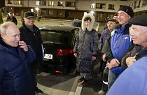 Sunday, March 19, 2023, Russian President Vladimir Putin talks with local residents during his visit to Mariupol.