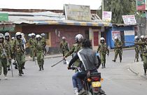 Riot police patrol Kibera slums as police clash with demonstrators during a protest.