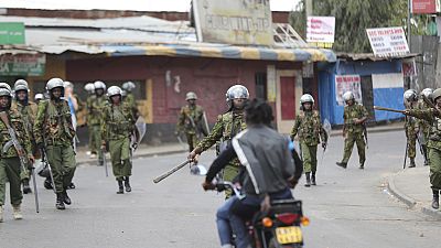 Riot police patrol Kibera slums as police clash with demonstrators during a protest.