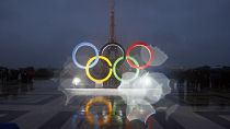 The iconic Olympic rings in front of the equally iconic Eiffel Tower in Paris