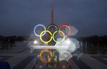 The iconic Olympic rings in front of the equally iconic Eiffel Tower in Paris