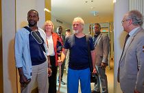 French journalist Olivier Dubois, left, and American aid worker Jeffery Woodke, center, arrive at the VIP lounge at the airport in Niamey, Niger, Monday March 20, 2023.