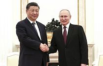 In this handout photo released by Russian Presidential Press Office, Russian President Vladimir Putin, right, and Chinese President Xi Jinping shake hands prior to their talks