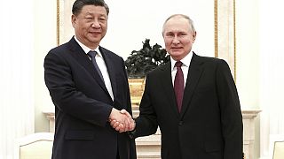 In this handout photo released by Russian Presidential Press Office, Russian President Vladimir Putin, right, and Chinese President Xi Jinping shake hands prior to their talks