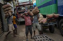 Laborers load sacks of imported potatoes to hand carts at a market place in Colombo, Sri Lanka, Tuesday, March 21, 2023. 