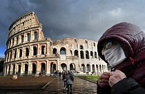 Une touriste porte un masque devant le Colisé, à Rome, Italie.
