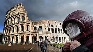 Turisti indossano la mascherina durante la loro visita al Colosseo