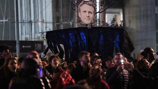متظاهرون يرفعون صورة لإيمانويل ماكرون خلال مظاهرة في باريس يوم السبت 18 مارس 2023.