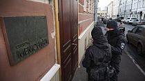 Two Russian police officers stand in front the door of the Memorial office in Moscow, Russia, Tuesday, March 21, 2023