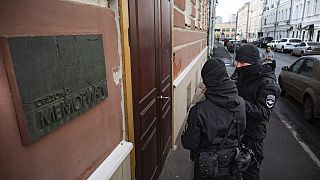 Two Russian police officers stand in front the door of the Memorial office in Moscow, Russia, Tuesday, March 21, 2023