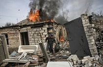 A man tries to save the belongings from a neighbour's burning house in Chasiv Yar, eastern Ukraine 21 March 2023