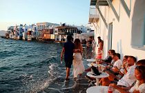 People sit at a bar in Little Venice on the Aegean Sea island of Mykonos, Greece, Sunday, Aug. 16, 2020.
