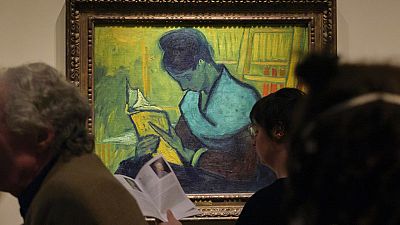 Visitors file past the Van Gogh painting "Une Liseuse De Romans", also known as "The Novel Reader"