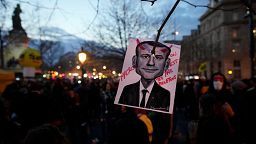A drawing of French President Emmanuel Macron reading « Macron , we are not your buffoons» is pictured during a protest at Republique square in Paris, Tuesday, March 21, 2023.