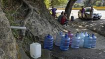 Жители пригородов Каракаса собирают питьевую воду из прорванных труб