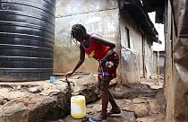 Une femme remplit son récipient avec de l'eau provenant d'un réservoir d'eau dans le bidonville de Kibera à Nairobi, au Kenya, le mardi 21 mars 2023. 