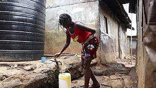 Une femme remplit son récipient avec de l'eau provenant d'un réservoir d'eau dans le bidonville de Kibera à Nairobi, au Kenya, le mardi 21 mars 2023. 
