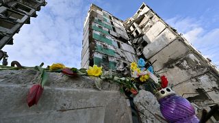 Flowers laid on a destroyed building in Ukraine. 