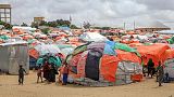Crianças somalis ao lado dos seus abrigos improvisados num acampamento