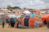 Crianças somalis ao lado dos seus abrigos improvisados num acampamento