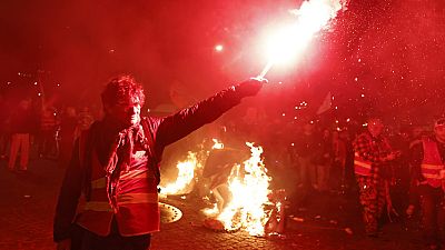 Protesters take part in a torchlight demonstration against the raising of the retirement age in Nantes, western France, Tuesday, March 21, 2023