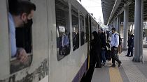 Passengers embark on a train at the main station in Athens, Greece, Wednesday, March 22, 2023.