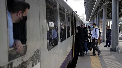 Pasajeros suben a un tren en Atenas, Grecia