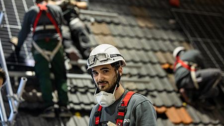 Solar power company Enpal trainee Milan Alexander is given instructions while installing solar panels at a training facility in Blankenfelde-Mahlow, south of Berlin 