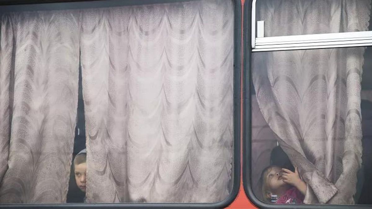 کودکان پیش از این که به ایستگاه برای انتقال به کمپ پناهندگان روسیه در حدود ۱۰ کیلومتری مرز اوکراین بروند از پنجره اتوبوس به بیرون نگاه می‌کنند. 