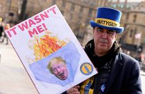 A protester shows a poster near Parliament in London, Wednesday, March 22, 2023. 