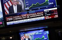 Οι οθόνες στην Wall Street δείχνουν τον κεντρικό τραπεζίτη των ΗΠΑ Τζερόμ Πάουελ κατά την ανακοίνωση της νέας αύξησης