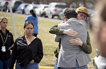Un estudiante, a la derecha, abraza a un padre en una manifestación después del  tiroteo en East High School, el miércoles, 22 de marzo de 2023, en Denver.