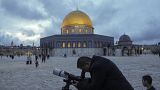 A man observes the moon through a telescope next to the Dome of Rock Mosque at the Al-Aqsa Mosque compound in Jerusalem's Old City, Tuesday, March 21, 2023