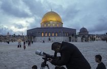 A man observes the moon through a telescope next to the Dome of Rock Mosque at the Al-Aqsa Mosque compound in Jerusalem's Old City, Tuesday, March 21, 2023