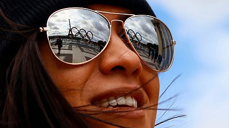 The Olympic rings are reflected on sunglasses, on Trocadero plaza that overlooks the Eiffel Tower in Paris.