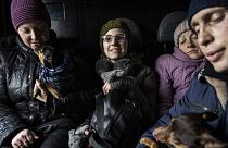 Arina, center, rides inside a car with her family during an evacuation by Ukrainian police, in Avdiivka, Ukraine, March 7, 2023. 