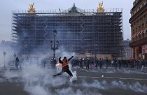 Manifestantes corren entre los gases lacrimógenos durante una manifestación en Lyon, en el centro de Francia, el jueves 23 de marzo de 2023. 