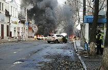 Cars burn and smoke raises after a deadly Russian rocket attack hit the city center in Kherson, Ukraine, Saturday, Dec. 24, 2022