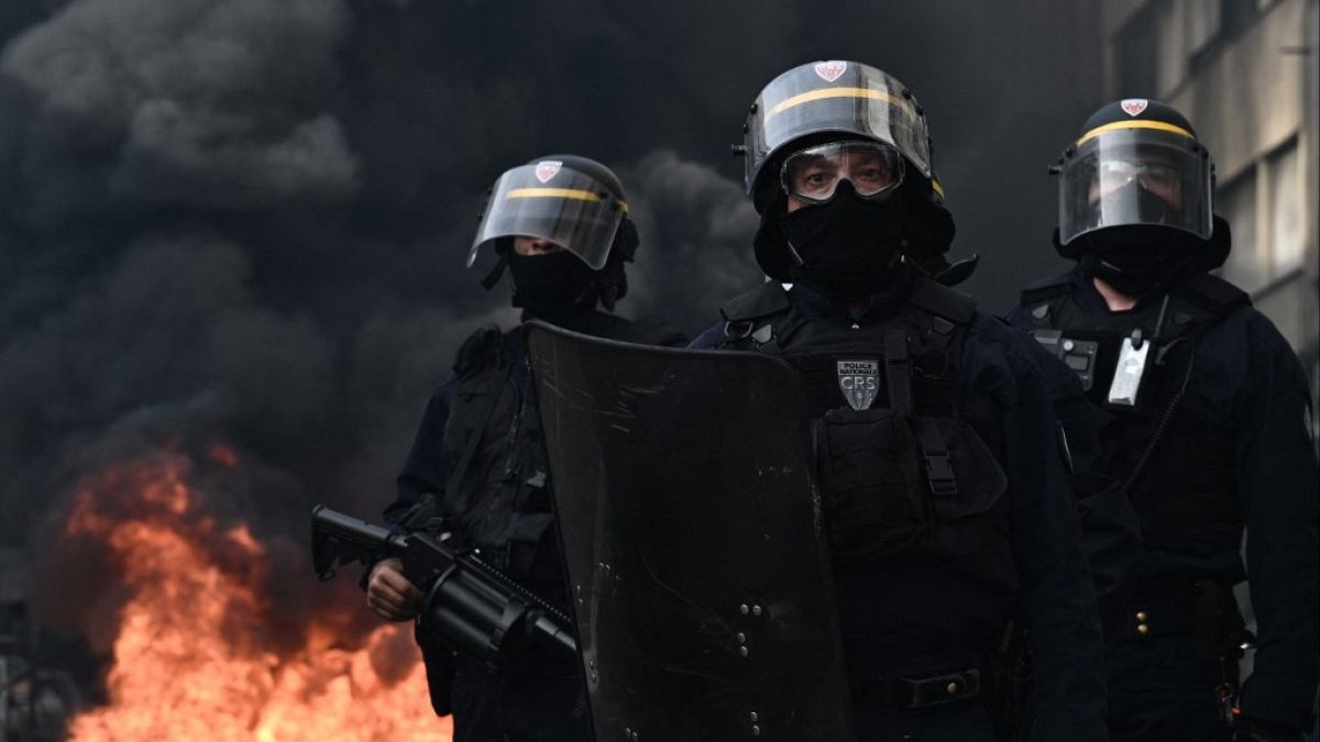 Riot police seen with smoke rising in the background in Bordeaux, western France, on March 23, 2023.