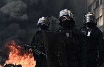 Riot police seen with smoke rising in the background in Bordeaux, western France, on March 23, 2023.