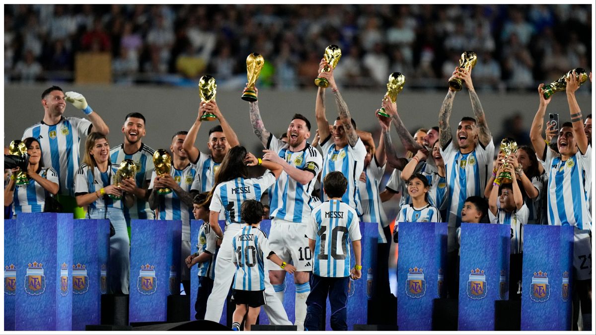 ميسي وهو يرفع نسخة من كأس العالم رفقة زملائه في المنتخب الأرجنتيني