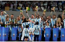 ميسي وهو يرفع نسخة من كأس العالم رفقة زملائه في المنتخب الأرجنتيني