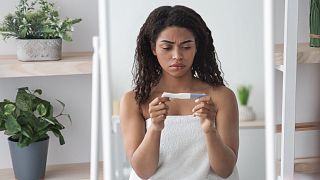 Eine Frau betrachtet das Ergebnis eines Schwangerschaftstests
