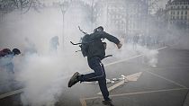 Une personne jette des pierres contre les forces de l'ordre en marge d'une manifestation contre la réforme des retraites, le 23 mars 2023 à Lyon, France
