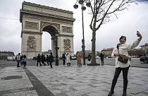  سائحة تلتقط صورة سيلفي بهاتفها المحمول في شارع الشانزليزيه مع قوس النصر، باريس، باريس، 12 يناير، 2023