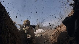 A Ukrainian soldier of the 28th brigade fires a grenade launcher on the frontline during a battle with Russian troops near Bakhmut, Donetsk region, Ukraine, 24 March 2023.