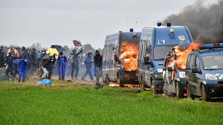 Горящие фургоны жандармов на акции экоактивистов, выступающих против строительства водохранилища на западе Франции, 25 марта 2023 года. 