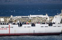 Migrantes a bordo de barco da guarda costeira italiana prestes a desembarcar em Reggio Calabria