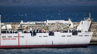 Migrantes a bordo de barco da guarda costeira italiana prestes a desembarcar em Reggio Calabria