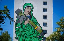 A mural depicts the Virgin Mary cradling a US-made Javelin missile on an apartment in Kyiv, Ukraine. 